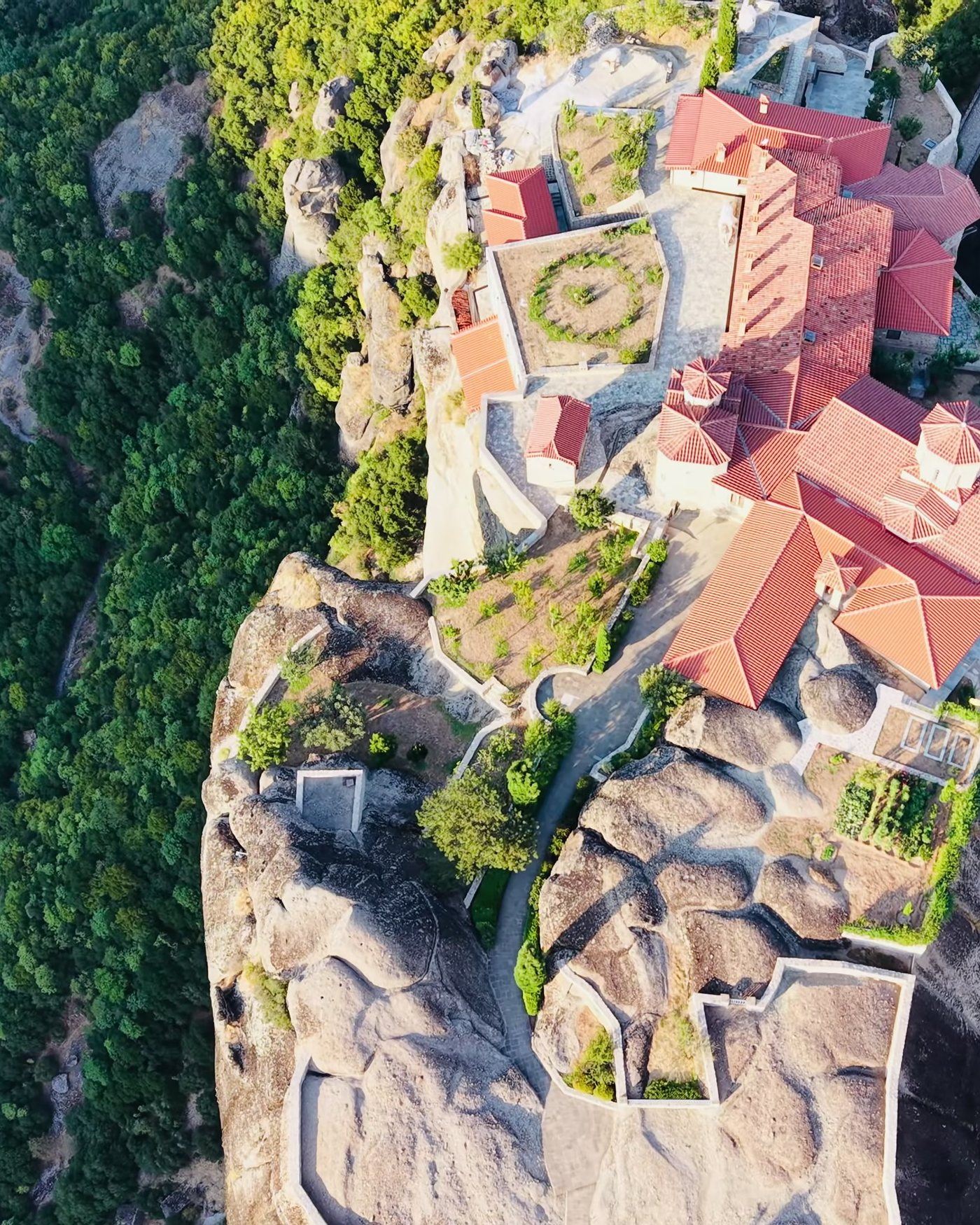 Cenital de un monasterio de Metéora: tejados rojos, terrazas y patio empedrado