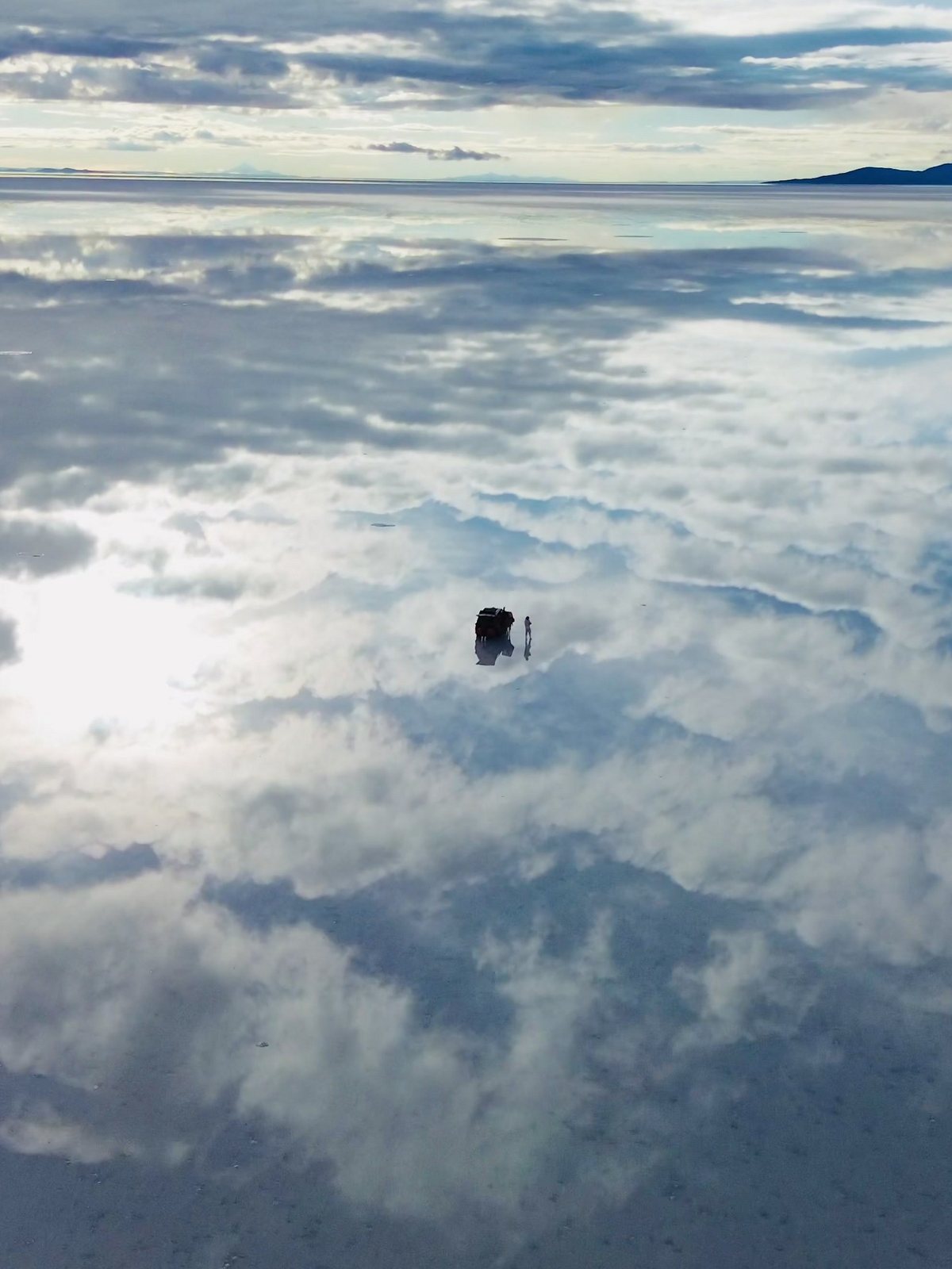 Lámina: un vehículo sobre el espejo del salar de Uyuni